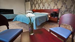 sypialnia z łóżkiem i wazonem z kwiatami na stole w obiekcie Residence Arx & Wellness w mieście Chrudim