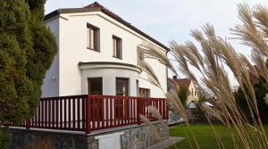 een wit huis met een rood hek en palmbomen bij Residence Arx & Wellness in Chrudim