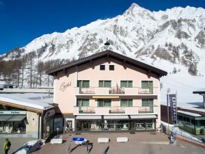 a hotel with a snow covered mountain in the background at Cristal Appartementhaus in Samnaun