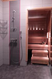 a bathroom with a walk in shower and a bench at Villa Saaruanniemi B in Ruka