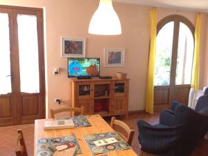 a living room with a table and a television at Casa Vacanze Valdicciola in Suvereto