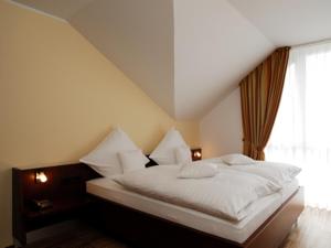 a bedroom with a white bed with a window at AKZENT Hotel Altenberge in Altenberge