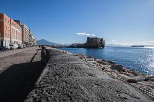 un muro di pietra accanto a un corpo d'acqua di Chiatamone Seaside Suite a Napoli