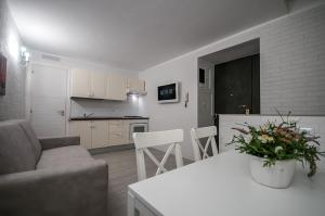 een woonkamer en een keuken met een bank en een tafel bij Chiatamone Seaside Suite in Napels