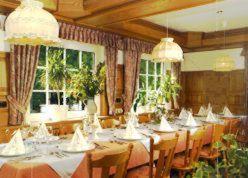 Gasthaus Laubacher Wald في Laubach: غرفة طعام مع طاولات وكراسي ونوافذ