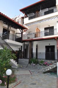 プサコウディアにあるGiannis Maria Apartmentsのバルコニーと中庭付きの広い白い家