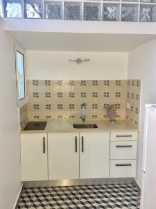 a kitchen with white cabinets and a sink at Rochinha Cozy Home in Funchal +108 photos