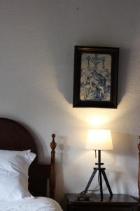 een slaapkamer met een bed en een schilderij aan de muur bij Cork Hills Farmhouse in Monte da Pedra +27 foto's