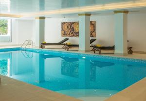 
a swimming pool with a chair and a tub in it at Theoxenia House Hotel in Athens
