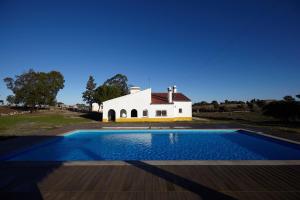 a house with a swimming pool in front of a building at Cork Hills Farmhouse in Monte da Pedra