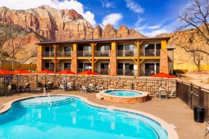 a hotel with a pool and mountains in the background at Best Western Plus Zion Canyon Inn & Suites in Springdale