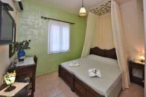 a bedroom with a bed with two towels on it at Mata's Apartments in Tinos +23 photos