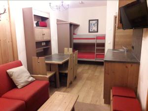 a small living room with a red couch and a table at T2 RESIDENCE ANTARES 4* pieds des pistes in Risoul