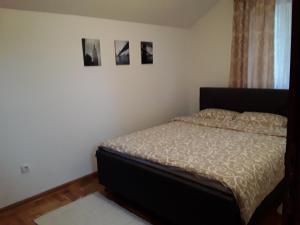 a bedroom with a bed and two pictures on the wall at Apartmani Ivanovic in Zlatibor