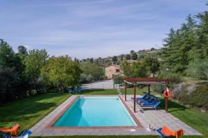 una piscina con sedie e gazebo di Villa Fontocchio a Cortona