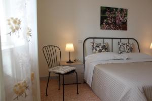 1 dormitorio con 1 cama, 1 silla y 1 lámpara en Aduepassidalmare, en Monopoli