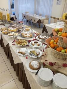 Hotel Adriatic&Beauty في ريميني: طاولة طويلة مع العديد من أطباق الطعام عليها