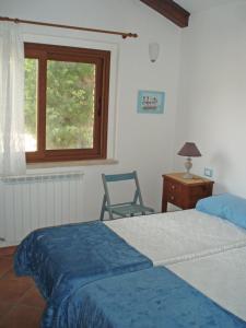 フランカヴィッラ・アル・マーレにあるLa Capannaのベッドルーム1室(ベッド1台、椅子、窓付)