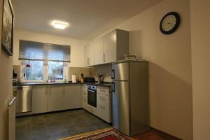 a kitchen with a refrigerator and a clock on the wall at City-Apartment - Lüneburg Schwalbengasse in Lüneburg