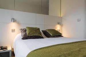 een slaapkamer met een wit bed met 2 kussens bij Hotel Expo in Brussel