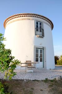 a white building with a table in front of it at Ha Mar ao Luar in Setúbal