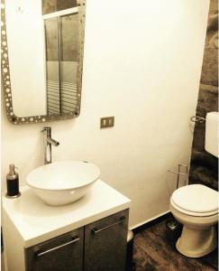 bagno con lavandino, servizi igienici e specchio di Casa mia a Palermo