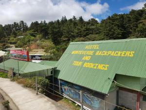 a building with a green roof with graffiti on it at Hostel Monteverde Backpackers in Monteverde Costa Rica