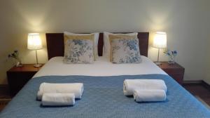 a bedroom with a large bed with two pillows at Casa das Conchas in Ericeira