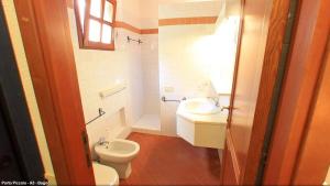 a bathroom with a toilet and a sink at Hotel Porto Piccolo in Baja Sardinia +39 photos