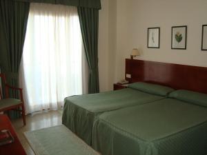 sypialnia z zielonym łóżkiem i oknem w obiekcie Hotel Bahía Bayona w mieście Baiona +22 zdjęcia