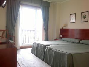 Łóżko lub łóżka w pokoju w obiekcie Hotel Bahía Bayona