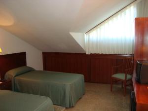 Łóżko lub łóżka w pokoju w obiekcie Hotel Bahía Bayona