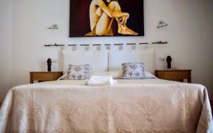 ゴルフォ・アランチにあるPedra Smeraldaのベッドルーム1室(壁に絵画が描かれた白い大型ベッド1台付)