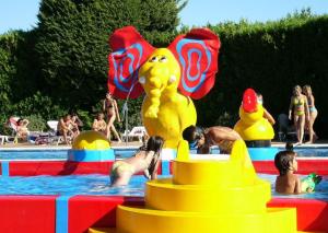 a group of people in a swimming pool with a pool toy at Camping La Pineda de Salou in La Pineda