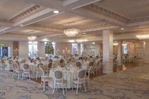 Four Seasons Hotel, Carlingford في كارلينغفورد: قاعة احتفالات كبيرة مع طاولات وكراسي بيضاء