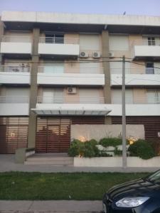 un edificio de apartamentos con un aparcamiento enfrente en Colina Garden en Victoria