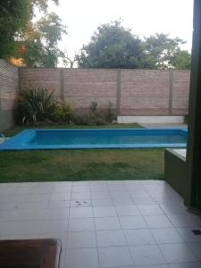 ein Pool in einem Garten neben einer Ziegelmauer in der Unterkunft Colina Garden in Victoria