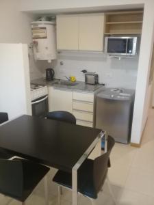 eine kleine Küche mit einem schwarzen Tisch und Stühlen in der Unterkunft Colina Garden in Victoria