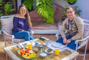 een man en een vrouw aan een tafel met eten bij Tzampoc Resort in Santa Catarina Palopó