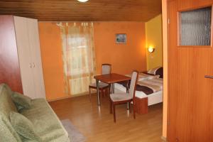 a room with a bed and a table and a couch at Zagroda Agroturystyczna Wiecha in Mieroszów