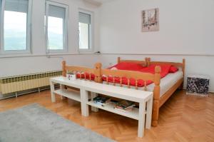 a bedroom with a bed and a table and windows at Apartments Villa Saray in Ohrid