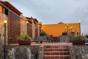 a patio with tables and chairs and a yellow building at Monte da Esperanca in Esperança