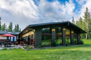 a house with a large window and a patio at Rustlers Lodge in Sundre