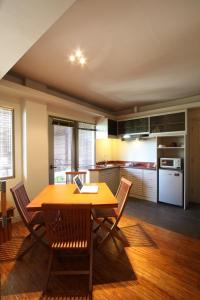cocina con mesa de madera y sillas en Sejuk Suites, en Legian