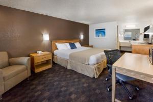 a small hotel room with a bed and a desk at Knights Inn Flint in Flint