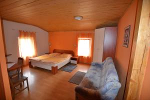 MieroszówにあるZagroda Agroturystyczna Wiechaのベッドルーム1室(ベッド1台、ソファ1台、窓2つ付)