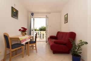 a living room with a red couch and a table at Sun House Apartments in Bol