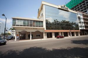 duży budynek na ulicy, przed którym zaparkowane są samochody w obiekcie Hotel Ramada w mieście Guayaquil