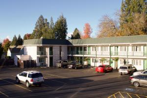 un gran edificio blanco con coches aparcados en un aparcamiento en Knights Inn Salem, en Salem