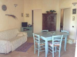 un soggiorno con tavolo, sedie e divano di Graziosissima villa a Capitana